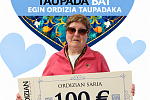 Ganador con cheque frente a corazón floral